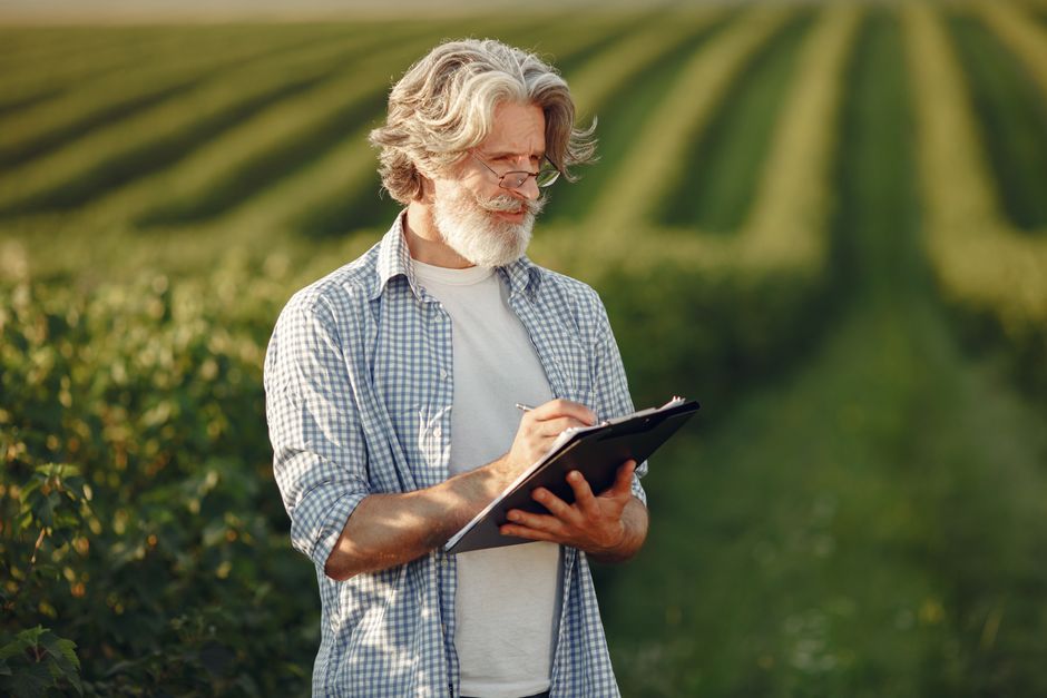 Agronomist analyzing crop data and soil reports at a workstation